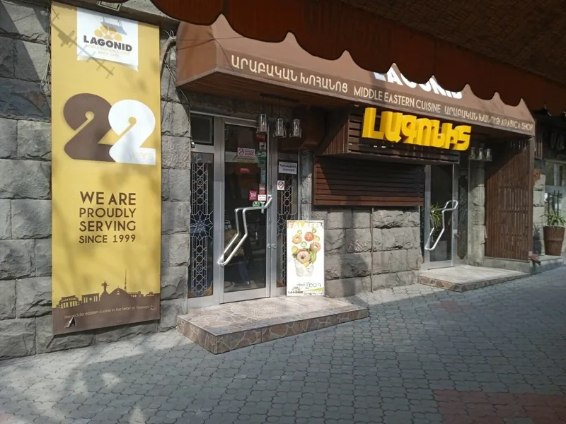 Lagonid front on the stone building with the yellow sign